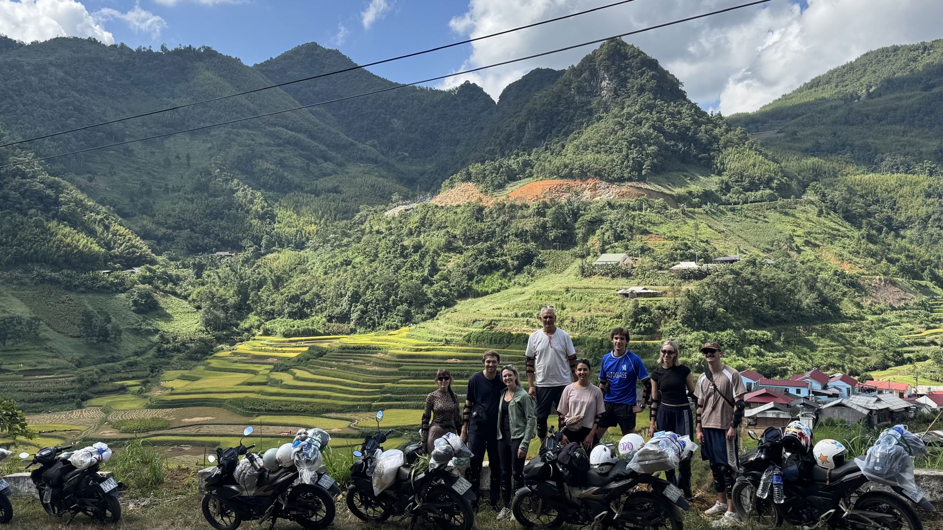 Guests with motorbikes in front of golden rice terraces on the Ha Giang and Cao Bang loop 